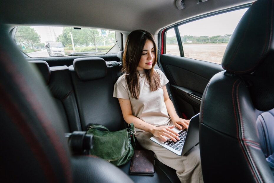 Woman using her laptop in the car